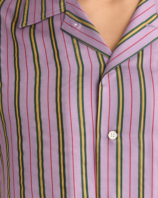 Close-up of the Alumni Stripe Long Sleeve Shirt - Purple, a men's shirt with bold red, green, and yellow stripes on purple fabric, accented by a crisp white button.