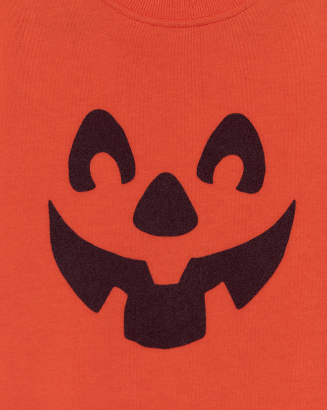 The Pumpkin Kids' Tee features a black jack-o’-lantern face on orange, creating a smiling pumpkin look that's perfect for a fun and playful Halloween shirt for children.