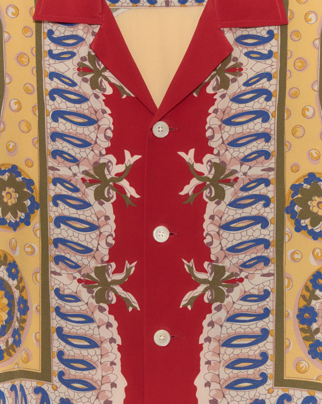 Close-up of the Bricolage Short Sleeve Shirt, a 1960s-inspired piece with vibrant red, yellow, and blue floral prints, white front buttons, and the luxurious feel of a printed scarf shirt.