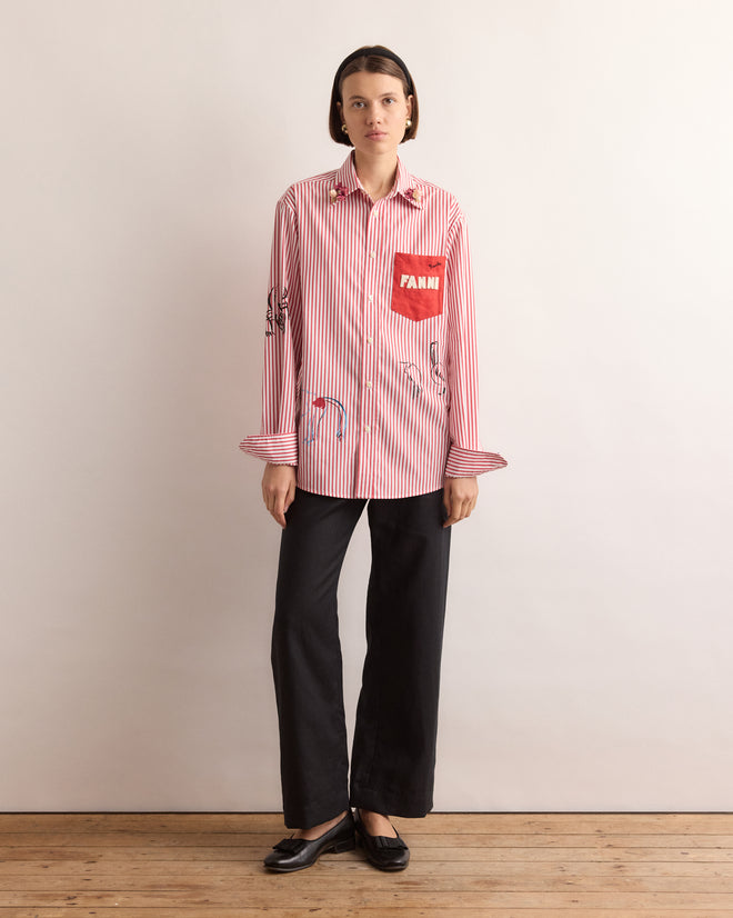 Woman in a Calder Painted Cirque Long Sleeve Shirt, black pants, and black shoes stands against a plain background—adding Alexander Calder-inspired flair and handmade New York style to her look.