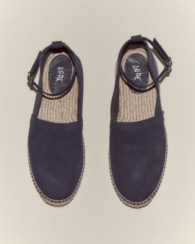 A pair of Canvas Slip-On Espadrilles - Navy with a classic jute sole is shown from above on a neutral background.