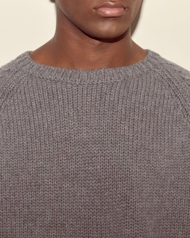 A person models the Cashmere Crewneck - Grey, visible from shoulders to lips against a light background.