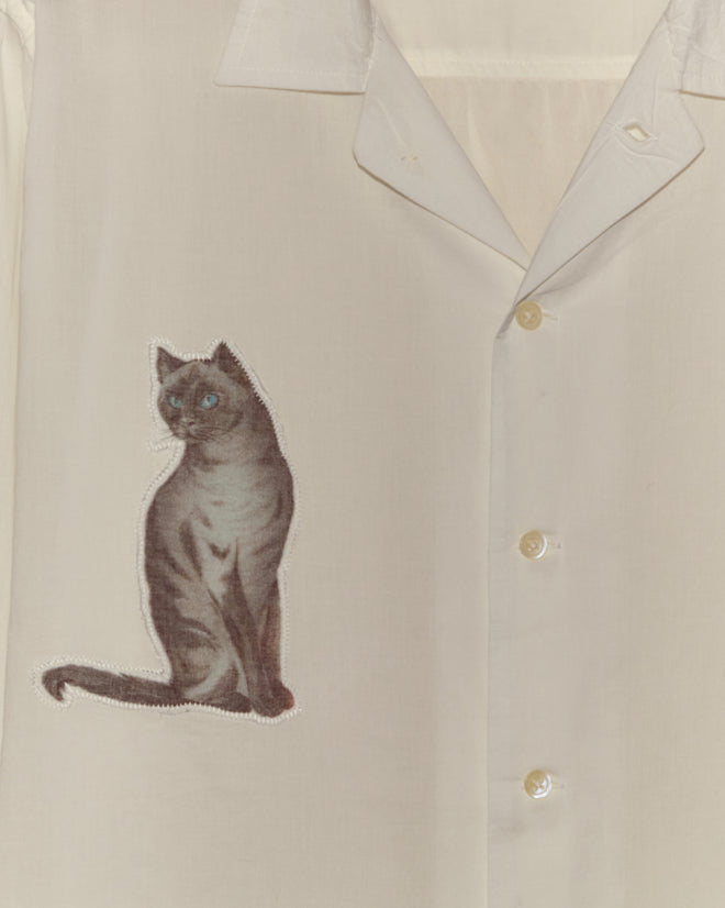 The Cat Motif Long Sleeve Shirt is a vintage-inspired cream top featuring a gray cat print on the left side.