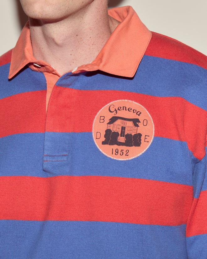 Person wearing the Clubhouse Rugby Shirt, a 100% cotton polo with wide red and blue stripes and a