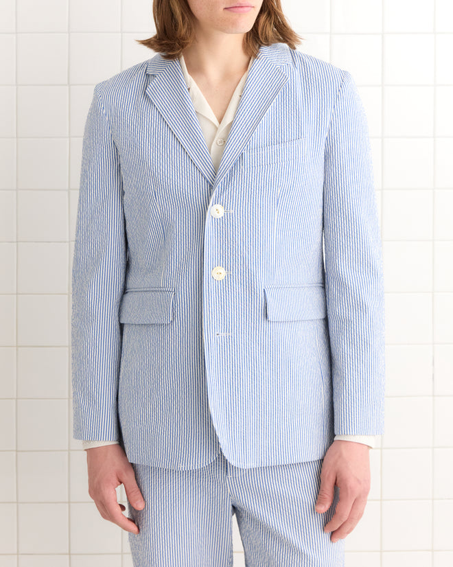 A person wears the Club Stripe Single-Breasted Suit Jacket in blue and white, set against a tiled white background.