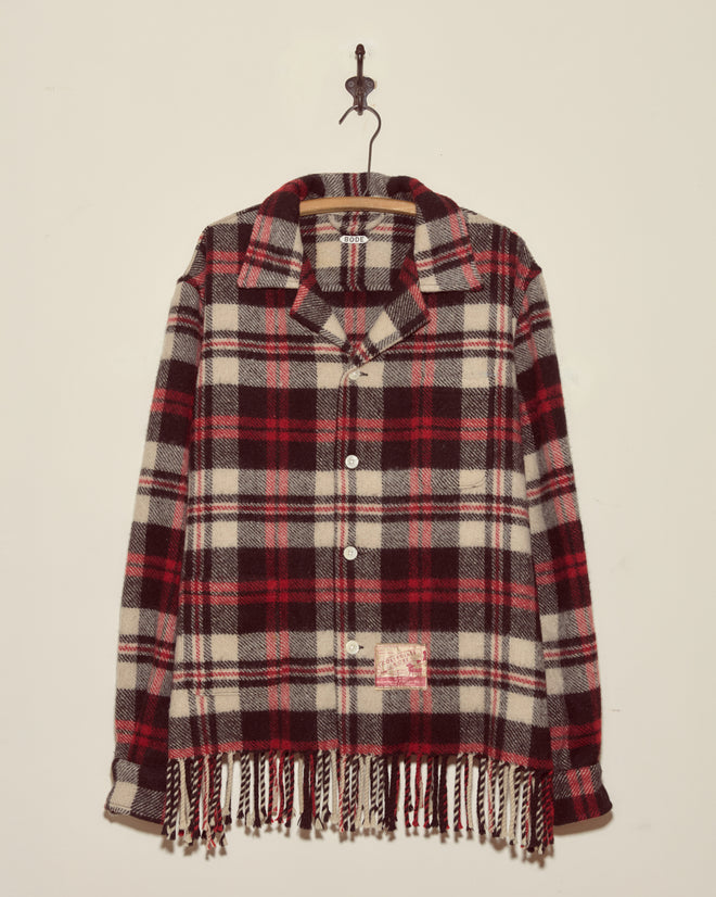 Collegiate Buffalo Overshirt - XXL: Red, black, and white plaid button-up with fringe at the bottom, made in New York by Brownsville Woolen Mills, hanging on a wall hook.