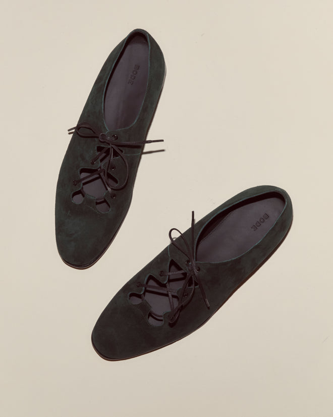 A pair of Suede County Clare Shoes - Green are displayed on a light beige surface.