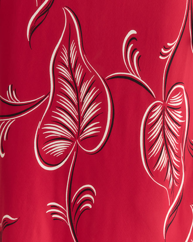 The Creeping Begonia Slip Dress features red fabric with a white and black botanical pattern, perfect for a bias cut silhouette.