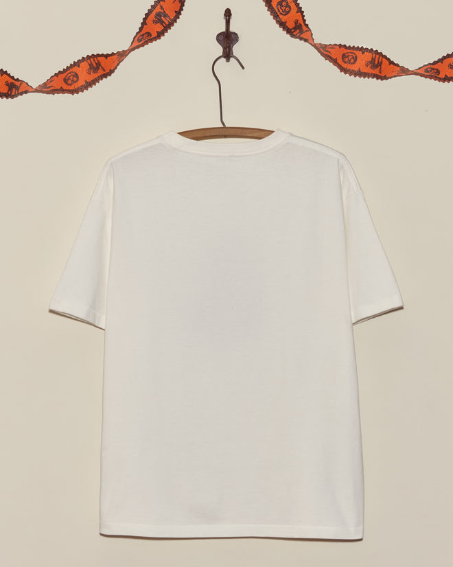 A Dracula Tee on a wooden hanger, with orange Halloween garland draped above it.