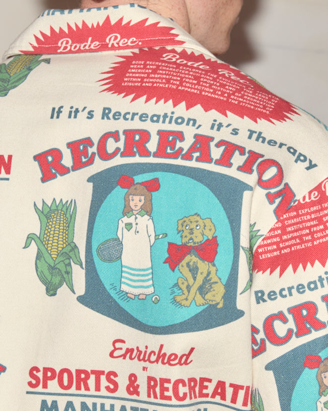 A close-up of the Enrichment Jacket featuring colorful vintage-style graphics and sports-themed text, inspired by classic feedsack jacket designs.