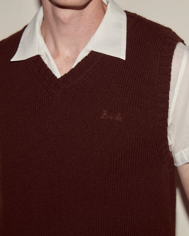 A person wears a white collared shirt under the Falls Vest in Dark Brown, highlighting classic men's knitwear crafted from a stylish wool-cashmere blend.