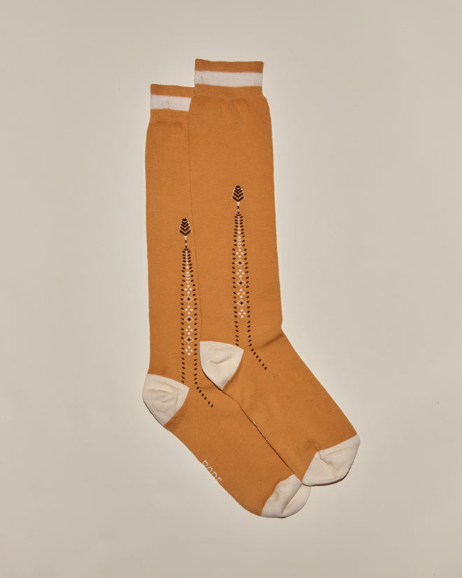 Geo Diamond Sock: Mustard yellow knee-high cotton socks with white toes, heels, and cuffs, featuring a black dotted geometric pattern for a vintage-inspired look.