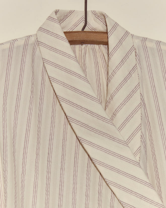 Lavender Sail Dress with thin brown vertical stripes and antique pearl buttons, displayed on a wooden hanger against a plain background.