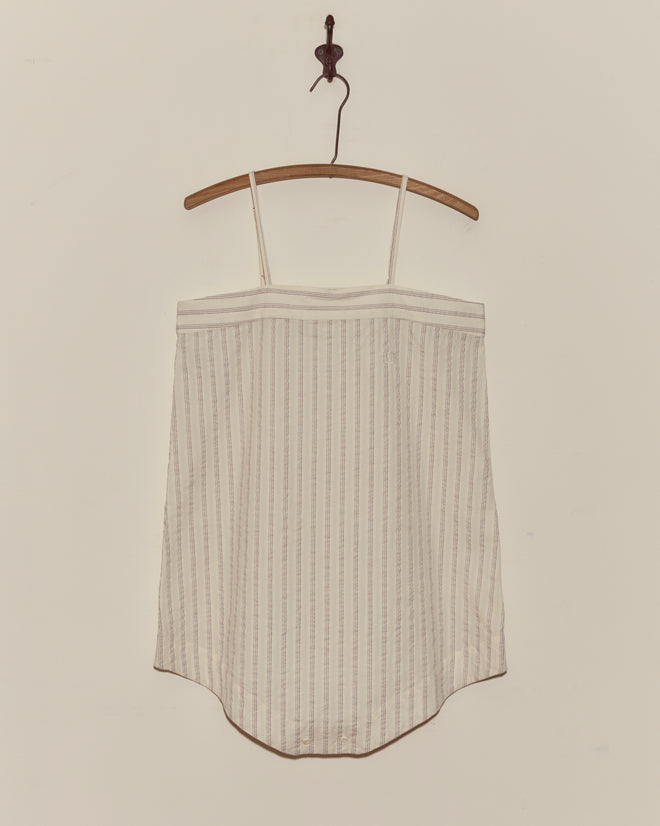 Lavender Sail Teddy with spaghetti straps, crafted from antique shirting fabric with vertical pastel stripes, hangs on a wooden hanger against a white wall.