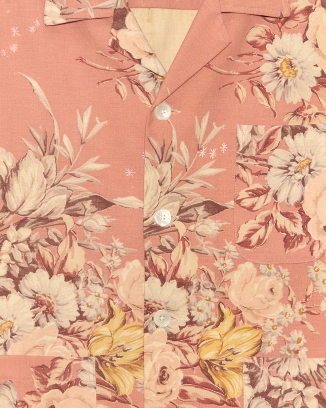 Close-up of the Lily Rose Long Sleeve Shirt - XS/S, a unique pink button-up with white, yellow, and brown florals and leafy patterns, inspired by vintage tablecloth styles.
