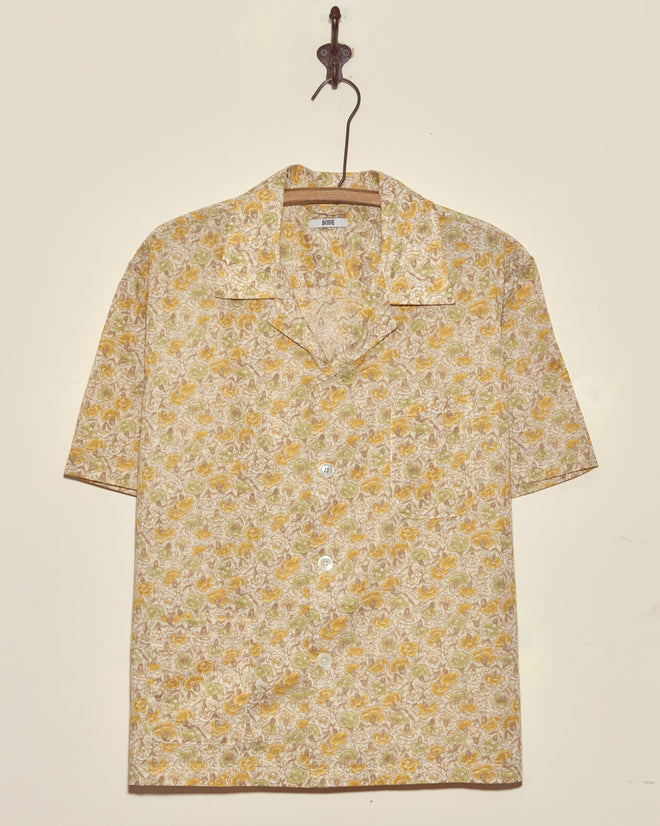 Lion's Mane Floral Shirt - M/L: yellow and white short-sleeve vintage button-up, displayed on a hook against a plain wall.