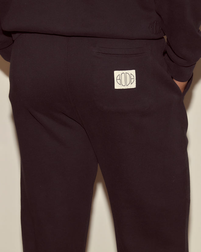 A person is seen from behind wearing black Joggers - Black, featuring a white