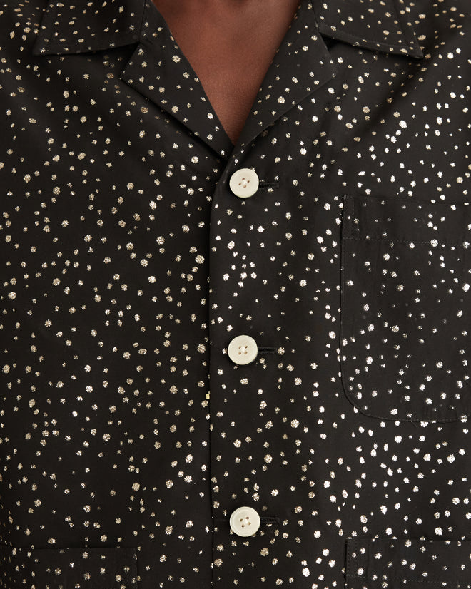 Close-up of the Glitter Shirt—a black shirt featuring glitter dots, white buttons, and a chest pocket, inspired by classic workwear jackets.