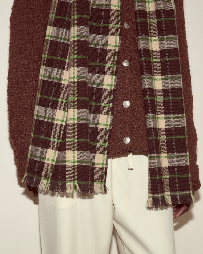 Person wearing a brown shirt with silver buttons, Woodcrest Scarf, and cream pants, shown from shoulders to thighs.