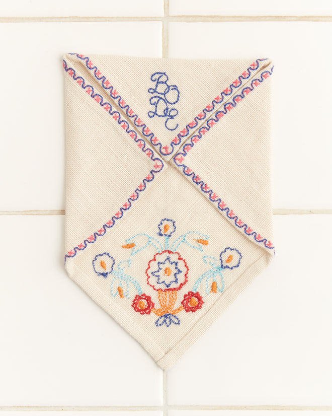 The Garden Party Cocktail Napkins, featuring embroidered floral and wavy designs with an elegant