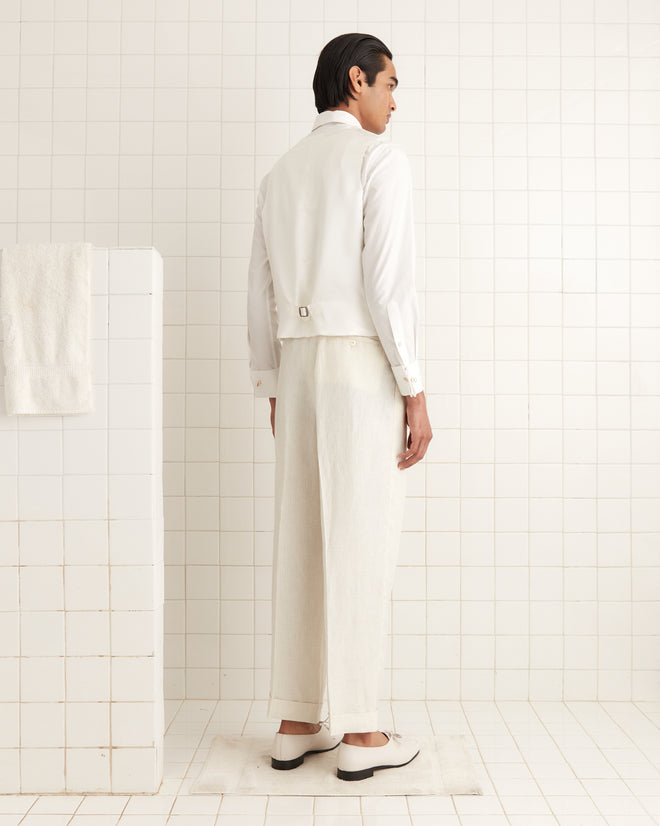 Dressed in a Nelson Brookline Waistcoat, a person stands in a tiled room wearing cream pants, embodying a 1940s-1950s style as they face away.