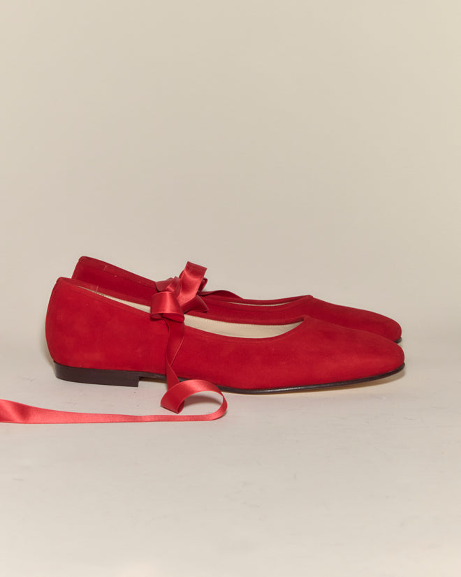 The Musette Flats - Chili are vintage-inspired red suede ballet flats, featuring a matching satin ribbon bow accent on one shoe.