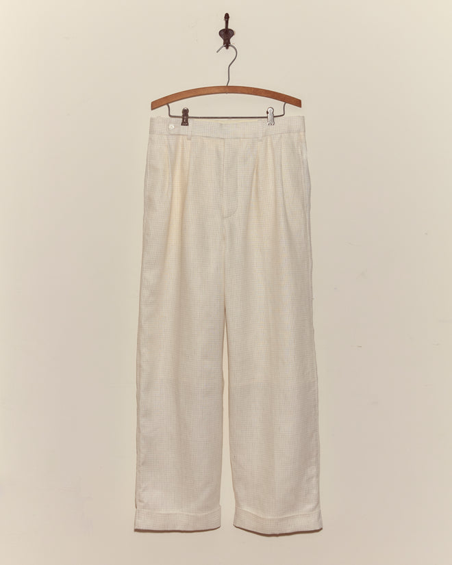 Nelson Trousers - Ecru wide-leg linen trousers displayed on a wooden hanger against a plain off-white wall.