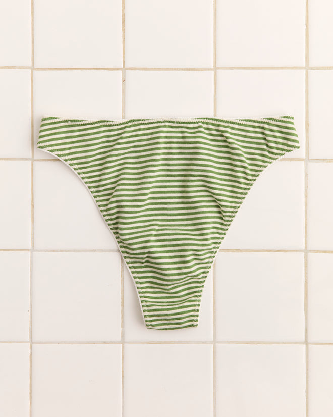 The Pony Briefs are green and white striped high-cut bikini bottoms, shown laid flat on white tiles, featuring an appliquéd horse patch and subtle Bode logo detailing.