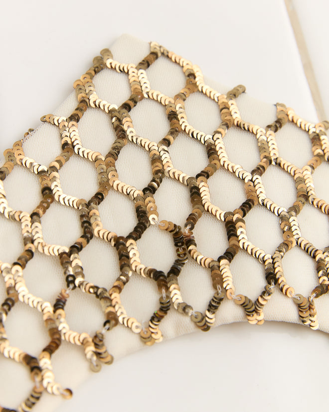 Close-up of Pinnacle Crown's white fabric with a golden sequin net pattern, reminiscent of a sequined crown, creating a shimmering effect.