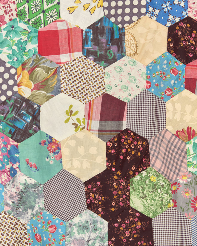The Rainbow Fish Quilt Shirt - XS/S features colorful hexagonal fabric pieces in floral, plaid, and geometric patterns, inspired by vintage patchwork quilts for a unique, one-of-a-kind look.