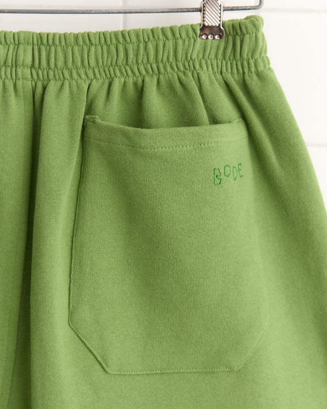 Close-up of Score Card Shorts: green cotton sweatshorts with an elastic waistband and a pocket embroidered with
