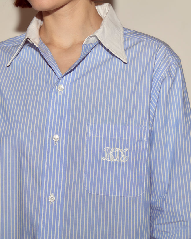 A person wearing a blue and white Signet Murray Shirt.