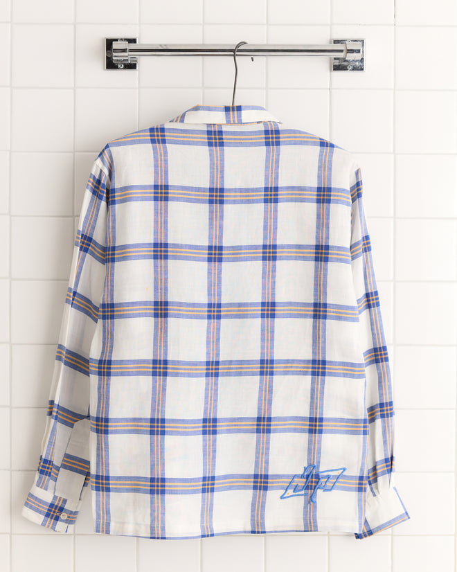 The Skylight Window Long Sleeve Shirt in XS/S features a unique white base with blue and red stripes, displayed on a metal hanger against a tiled wall.