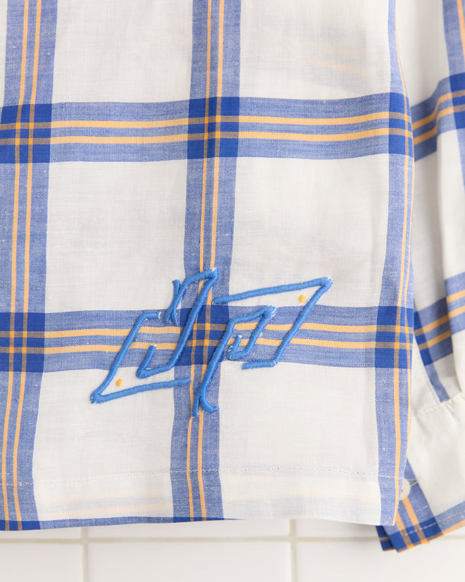 The Skylight Window Long Sleeve Shirt (XS/S) is made from vintage white bedsheets with blue and yellow plaid, featuring blue embroidered letters by the hem—a unique monogram piece.