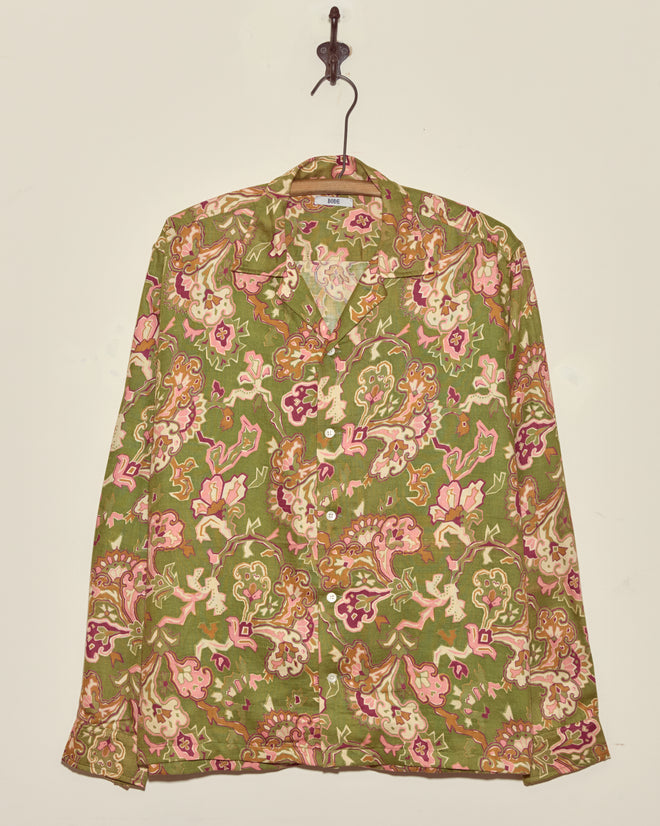 Smoke Moss Shirt - M/L: Green long-sleeve vintage shirt with a colorful floral and paisley pattern, displayed hanging on a hook against a plain wall.