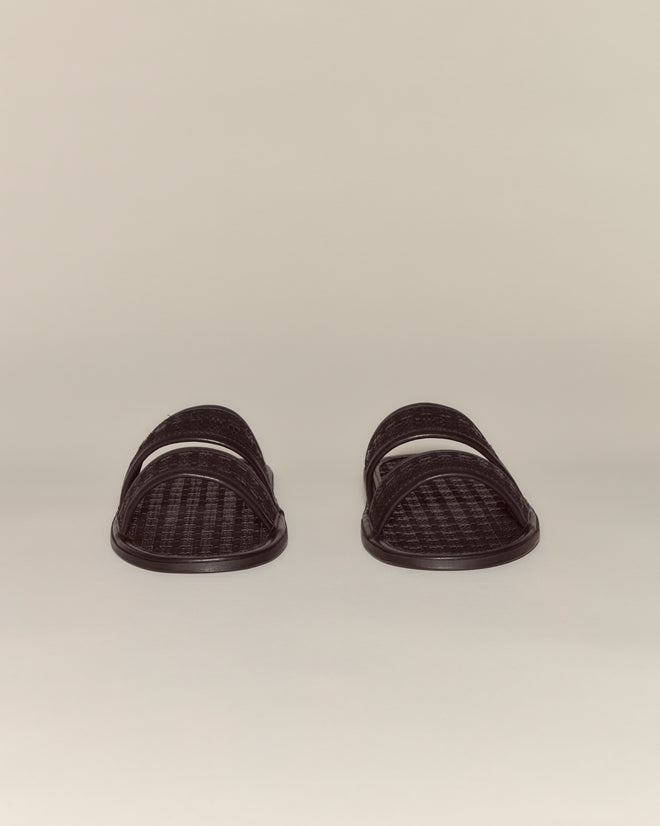 The Solid Summer Slides are black calf leather woven sandals with two straps, ideal for summer and showcased on a neutral background.