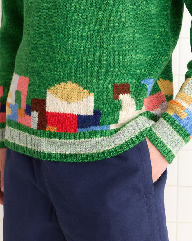 Wearing the Swatch Sweater - Green with colorful geometric patterns and blue pants gives off a vintage vibe, perfect for a leisurely Port Renfrew stroll.