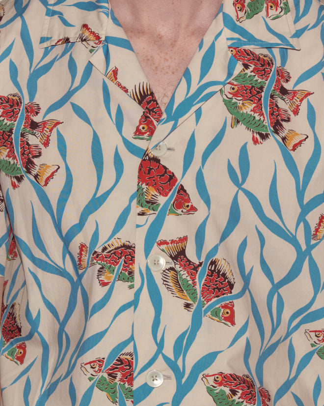 Close-up of the Swimmers Short Sleeve Shirt, featuring a blue seaweed cotton fabric with a vibrant fish and seaweed pattern and crisp white buttons.