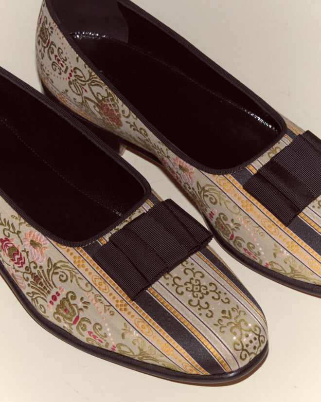 Floret Brocade Opera Pumps: Italian-made flats featuring a floral and striped cream brocade, finished with elegant black ribbon bows, inspired by classic Opera pumps.