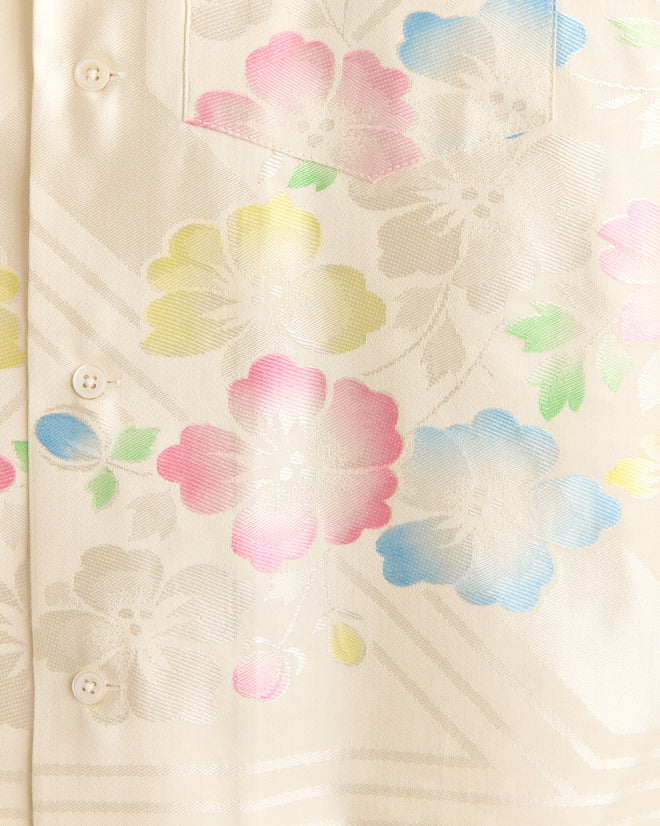 Close-up of the Waterlily Stencil Shirt - XS in cream, showcasing pastel pink, blue, yellow, and green floral patterns.