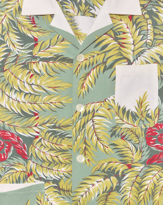 Close-up of the Windy Fronds Shirt - S/M, uniquely crafted from a vintage tablecloth with green, yellow, and red tropical leaves, finished with a crisp white collar, buttons, and pocket.