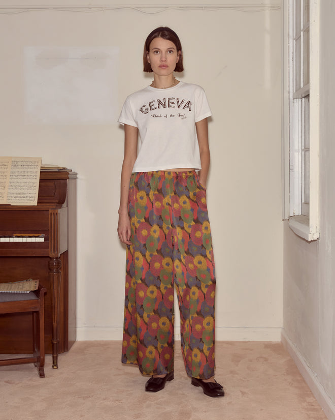 Woman stands indoors by a piano, wearing a
