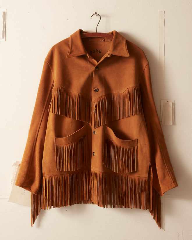 The Appalachian Jacket - Camel is a brown suede jacket with fringe on the chest, pockets, and hem, bringing classic Western style to any wall or wardrobe.