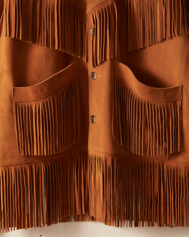 Close-up of the Appalachian Jacket - Camel: a brown suede jacket featuring long fringe details and large front pockets, perfect for adding Western flair to your costume or pairing with denim for a classic look.