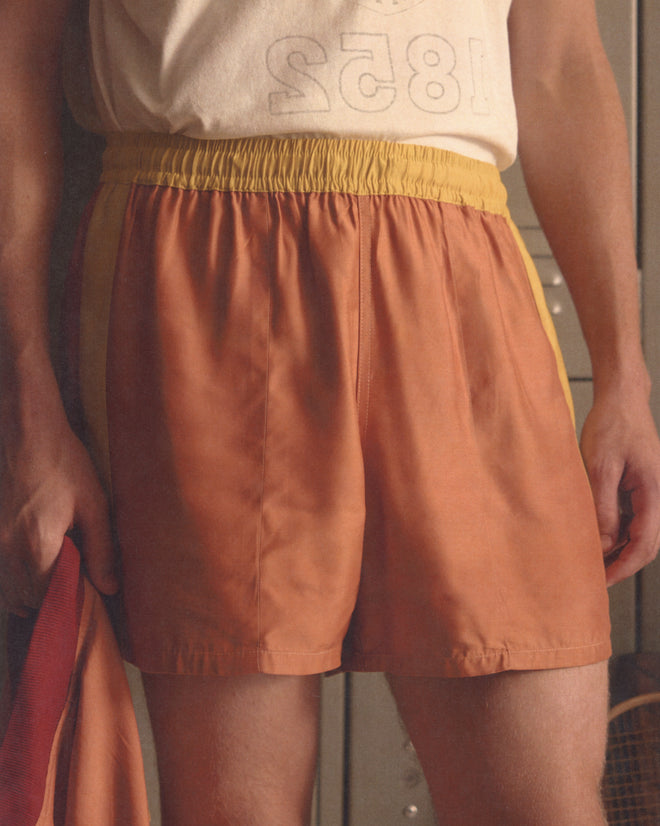 Person wearing Satin Field Shorts - Orange paired with a light shirt, standing indoors.