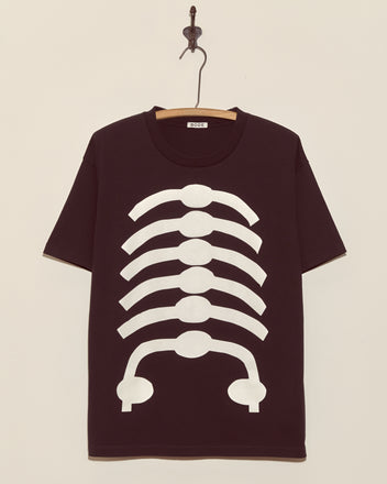 The Skeleton Tee features a black base with a white ribcage graphic on the front, displayed on a wooden hanger—ideal for Halloween or vintage skeleton-inspired looks.