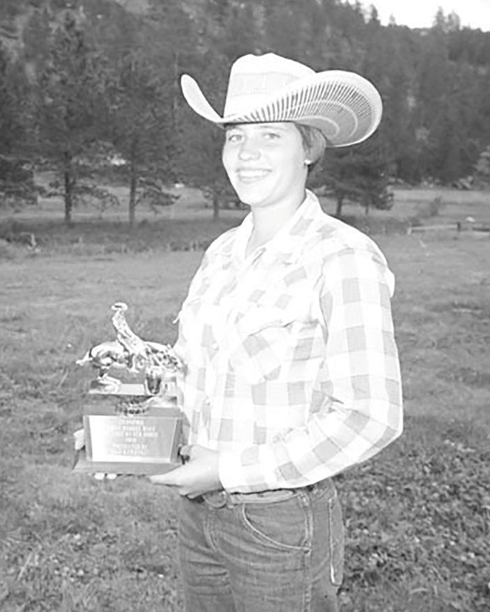 Historic photo of a barrel racer holding a rodeo trophy.
