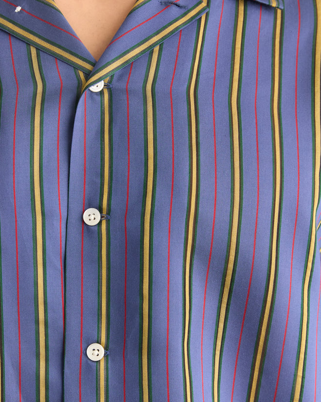 Close-up of the Alumni Stripe Long Sleeve Shirt- Blue, inspired by 1960s-1980s style, with a blue base and green, yellow, and red vertical stripes, white buttons, and made from a viscose silk blend.