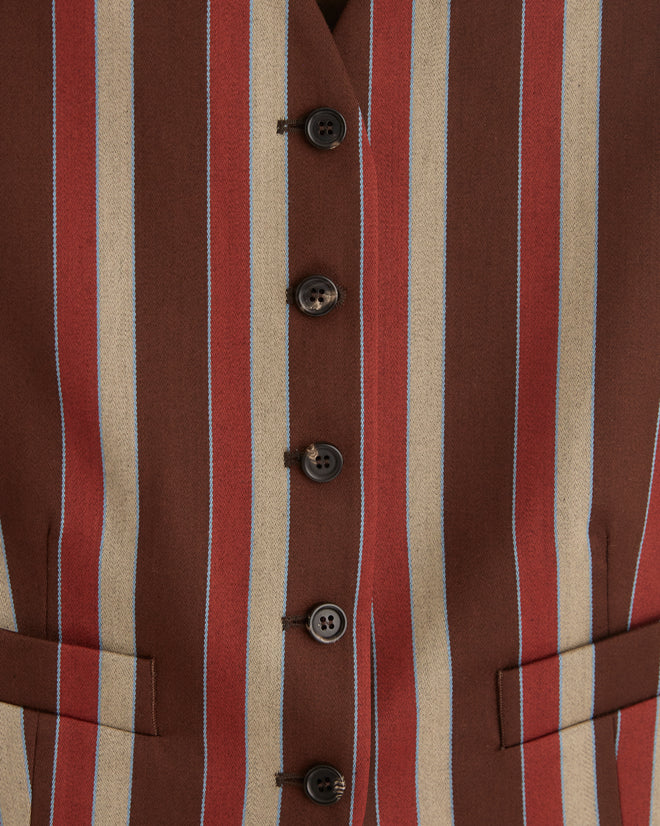 A person in an Arizona Stripe Waistcoat paired with a white shirt stands against a dark background, hands behind their back.