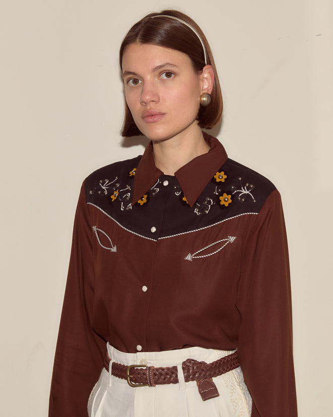 Woman with a brown bob hairstyle, wearing the Abilene Western Shirt and white high-waisted pants.